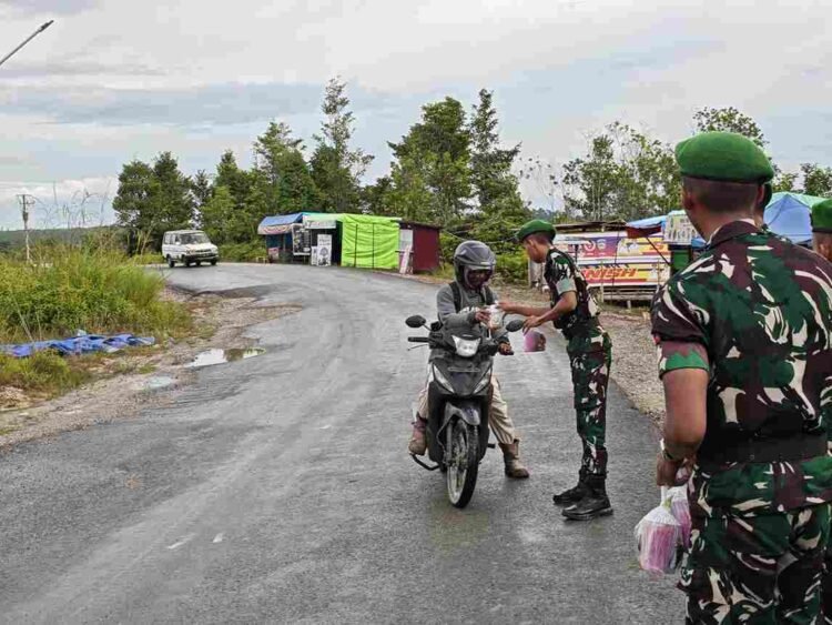 Yonif TP 880/Banuanta Bagikan Takjil kepada Pengendara